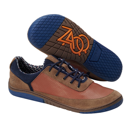 Wir präsentieren den AQTIV Brown von ZAQQ, ein Paar stylische Freizeitschuhe. Diese Schuhe haben Obermaterial aus braunem und marineblauem Leder, marineblaue Schnürsenkel und kontrastierende blaue Sohlen. Die Gummisohlen haben ein innovatives orangefarbenes ZOO-Logomuster für besseren Halt. Genießen Sie flexible Bewegungen mit dem schwarz-weißen geometrischen Futter, das die Atmungsaktivität steigert.