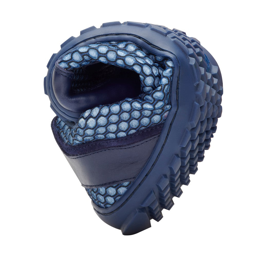Primer plano de una zapatilla TOQIO Navy de ZAQQ, que muestra su suela flexible y estructurada en forma compacta. El zapato destaca su diseño moderno con un patrón de panal en la parte superior y tejido de malla transpirable, que enfatiza la flexibilidad.