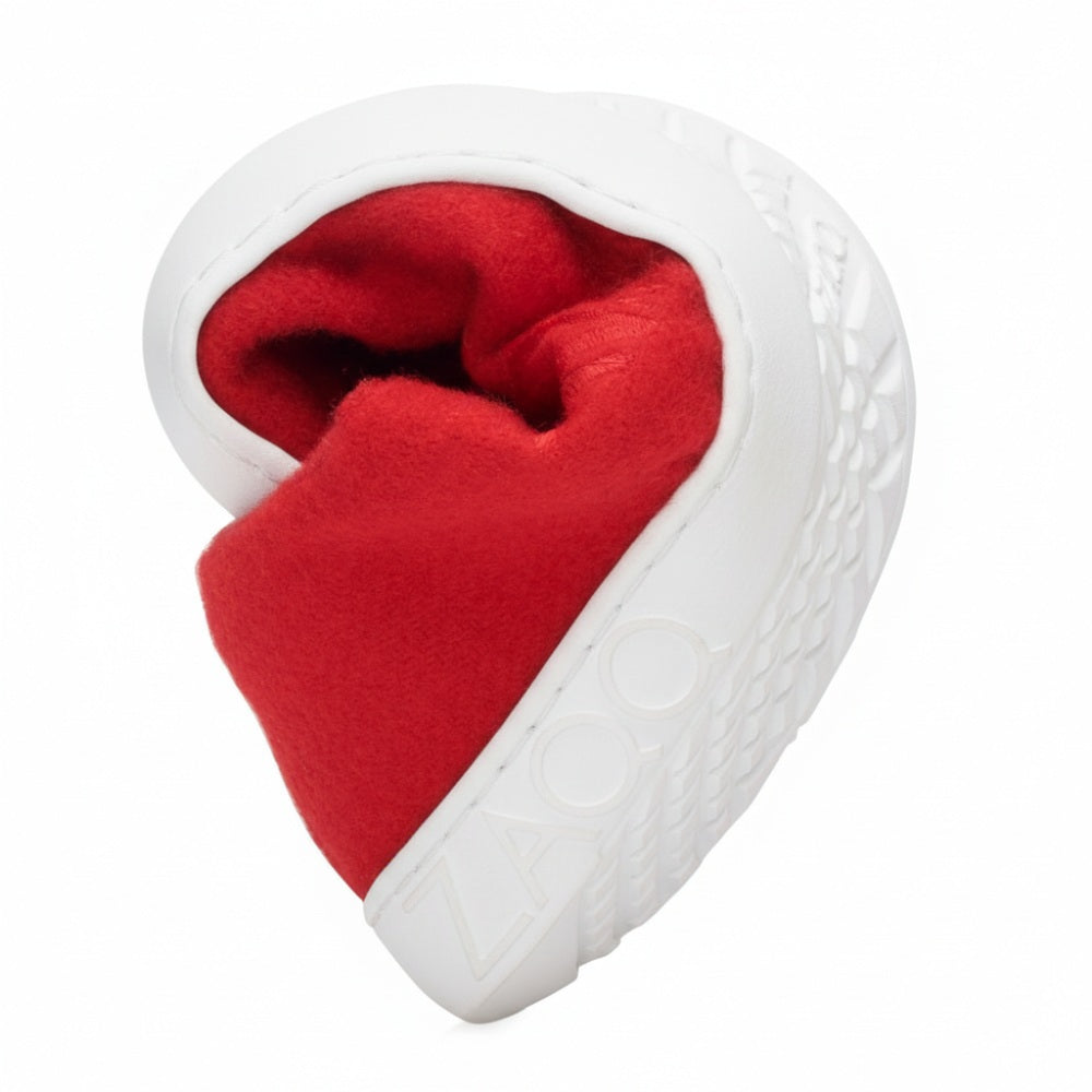 Ein geformter grauer Stein in Form eines Ohrs mit detaillierter Struktur faltet sich um ein leuchtend rotes Tuch und erinnert an den LIQE Race Sneaker, der für den Komfort einer Barfußsohle gefertigt wurde. Das Wort ZAQQ ist in die Oberfläche des Steins eingraviert.