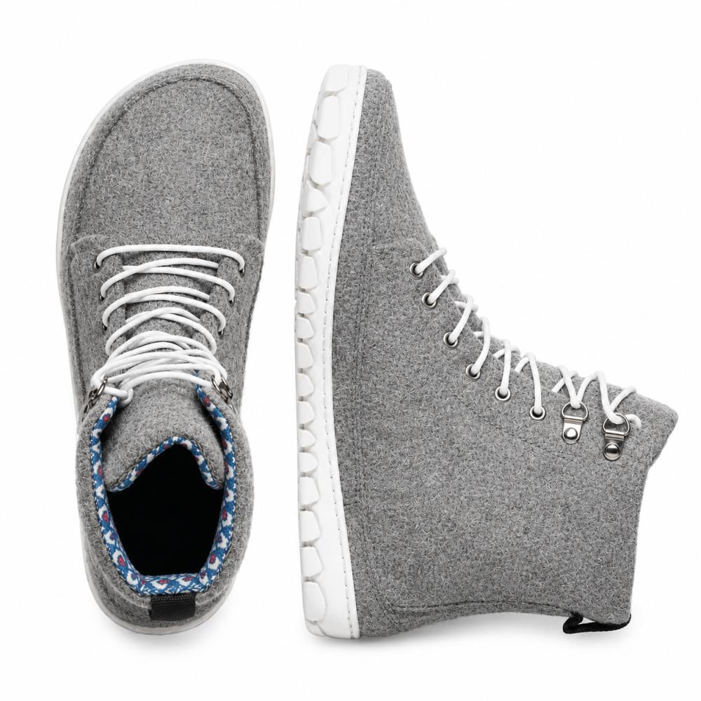 Presentamos el QICE Grey de ZAQQ: Estas zapatillas tienen un diseño de caña alta en gris con cordones blancos y ofrecen una buena vista tanto desde arriba como desde el lateral. Su característica destacada es una suela exterior texturizada única que proporciona más estilo y comodidad. Están hechas de materiales similares a la lana merina y ofrecen una mezcla llamativa de comodidad y moda.