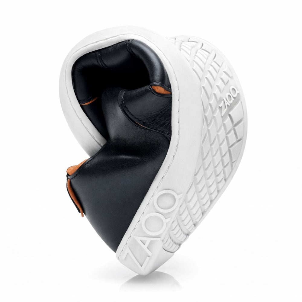 Ein vielseitiger Barfuß-Sneaker, der QQQ Low Black Orange von ZAQQ, zeigt seine Flexibilität mit einer herzförmig gebogenen Sohle. Er verfügt über eine strukturierte weiße Außensohle und ist mit dem Markennamen auf der Ferse verziert. Das Innere verfügt über ein veganes Futter für einen umweltfreundlichen Look.