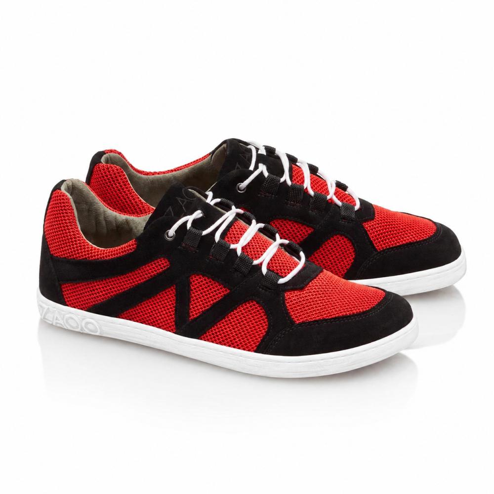 Un par de zapatillas QUSQO Red de ZAQQ con una combinación de inserciones de malla roja y acentos de ante negro, completos con cordones blancos y una suela blanca. Estos zapatos para correr tienen un exclusivo diseño de costura en forma de onda en el lateral y el nombre de la marca elegantemente colocado en el talón.