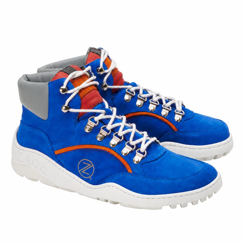 Las zapatillas impermeables TERRAQ Azure de ZAQQ son de un azul brillante con puños grises en los tobillos y acentos rojo-naranja. Están diseñadas como calzado para exteriores y cuentan con cordones blancos con ojales plateados, así como una suela blanca gruesa y distintiva que proporciona tracción óptima.