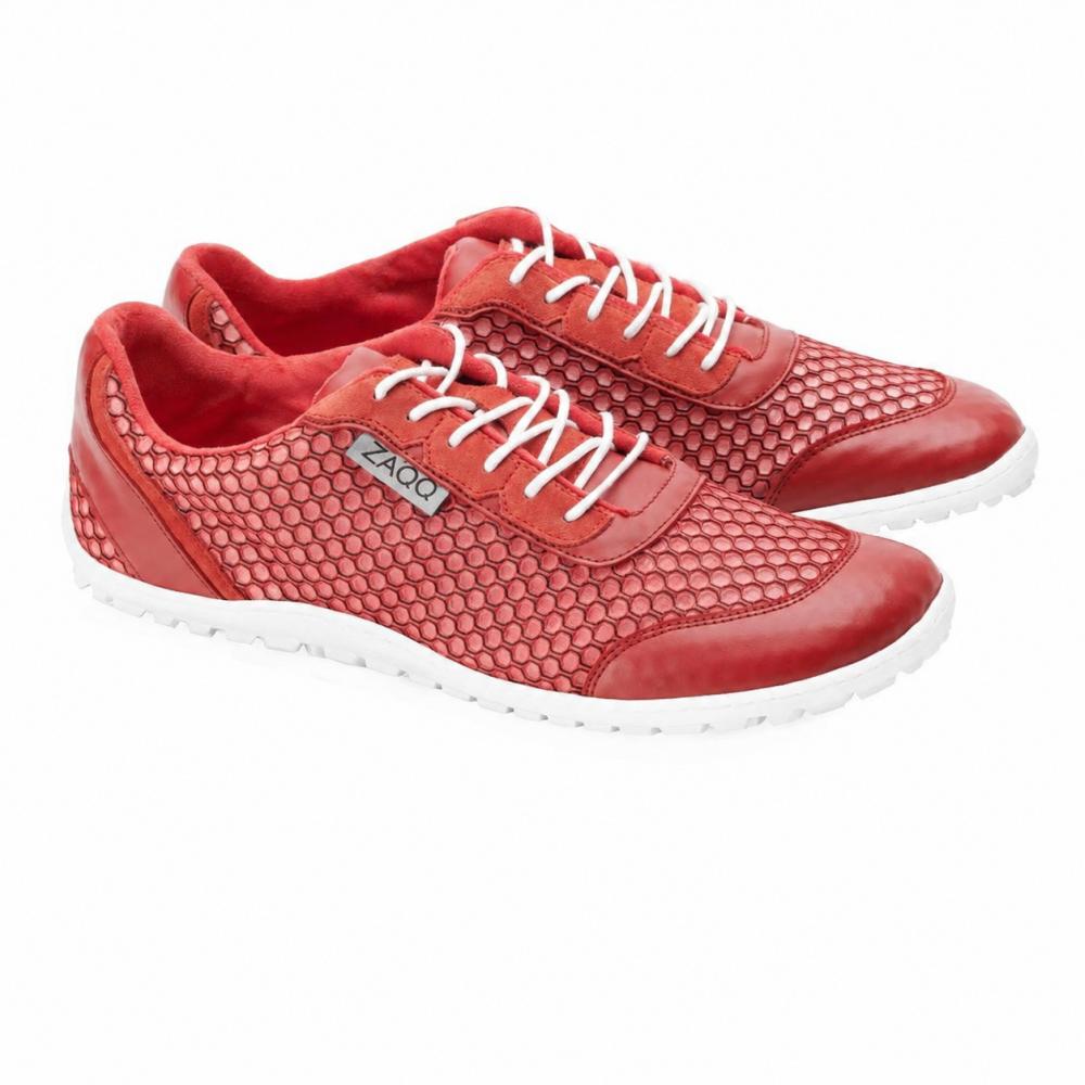 Un par de zapatillas TOQIO Red de ZAQQ, con un diseño ultramoderno con parte superior roja, acentuado por cordones blancos y detalles de malla hexagonal. Estos zapatos muestran con orgullo una elegante suela blanca y una etiqueta con el logotipo de la marca en el lateral, elegantemente colocados uno al lado del otro sobre un fondo blanco impecable.